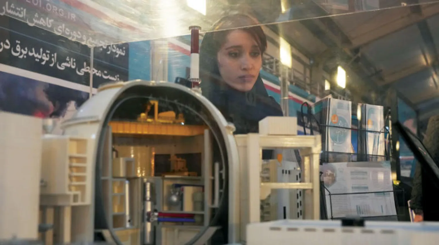 طالبة تتفقد نموذجاً لمفاعل بوشهر النووي الإيراني في معرض بطهران 8 فبراير (أ.ب)
