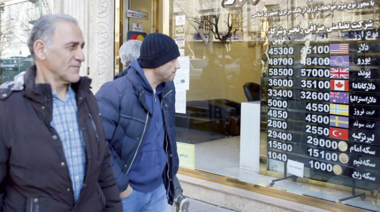 رجل إيراني ينظر إلى لوحة في واجهة محل صرافة في طهران الأربعاء الماضي (إ.ب.أ)