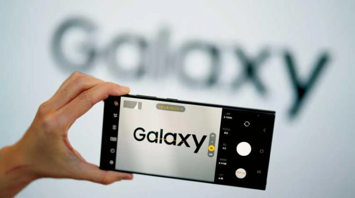 امرأة تستعرض الهاتف الذكي الجديد سامسونغ (أ.ب)