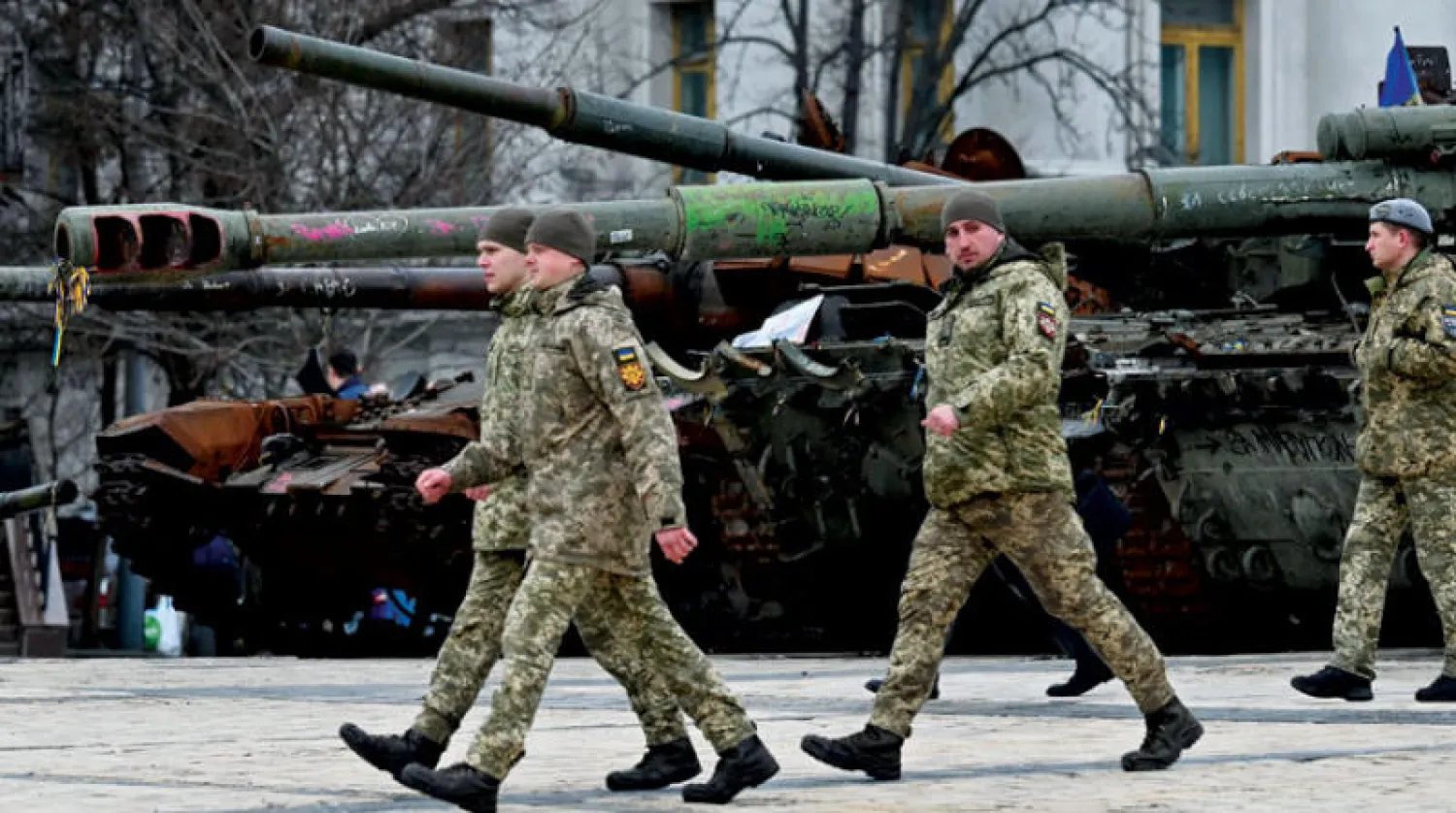 ضباط أوكرانيون يمرون أمام قطع عسكرية روسية مدمّرة في كييف أمس (أ.ف.ب)