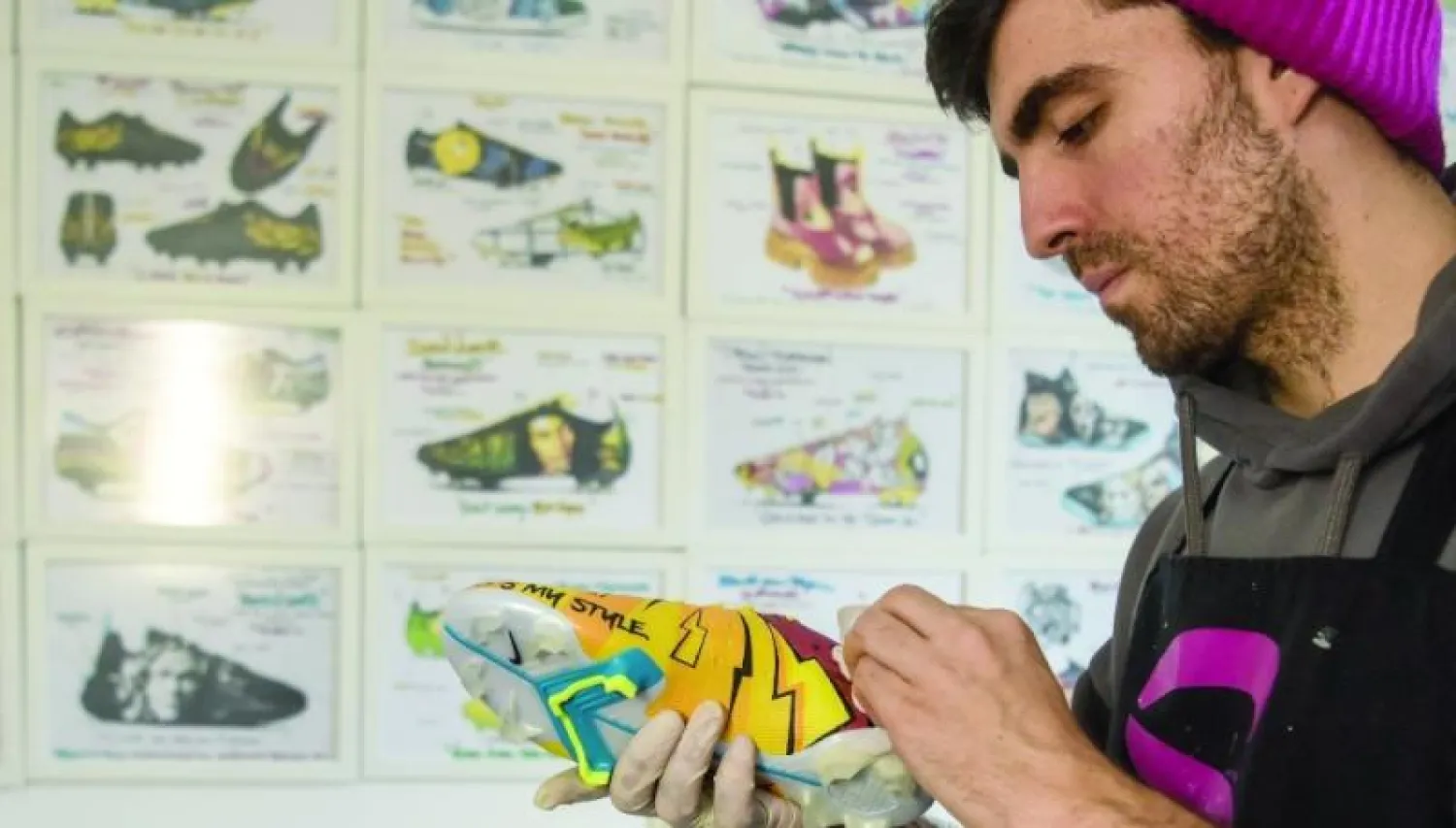 ساتيا غرابولوسكي أثناء تزيينه حذاء رياضياً في ورشته في سكوبيي (أ.ف.ب)
