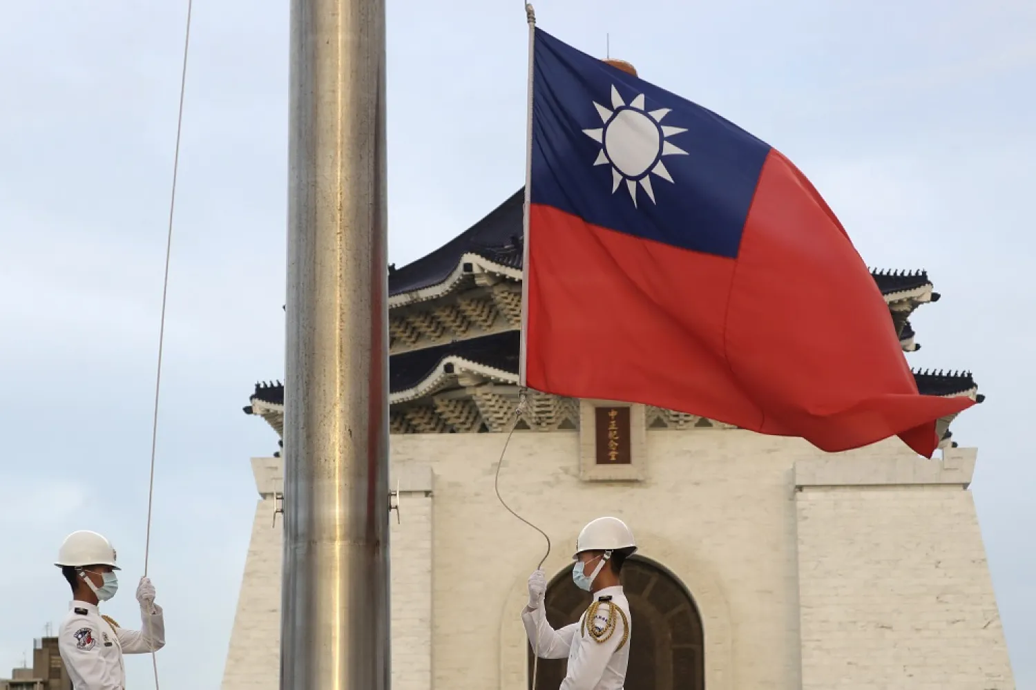 Two soldiers lower the national flag during the daily flag ceremony on Liberty Square of the Chiang Kai-shek Memorial Hall in Taipei, Taiwan, July 30, 2022. (AP)
