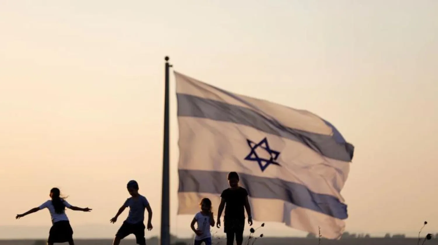 Israeli kids play next to an Israeli flag next to the Israeli Syrian border at the occupied Golan Heights, Israel July 23, 2018. REUTERS/Ronen Zvulun/File Photo
