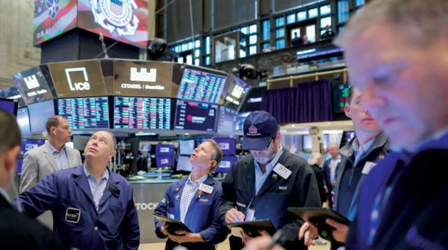 متداولون يتابعون حركة الأسهم على الشاشات داخل بورصة نيويورك (رويترز)