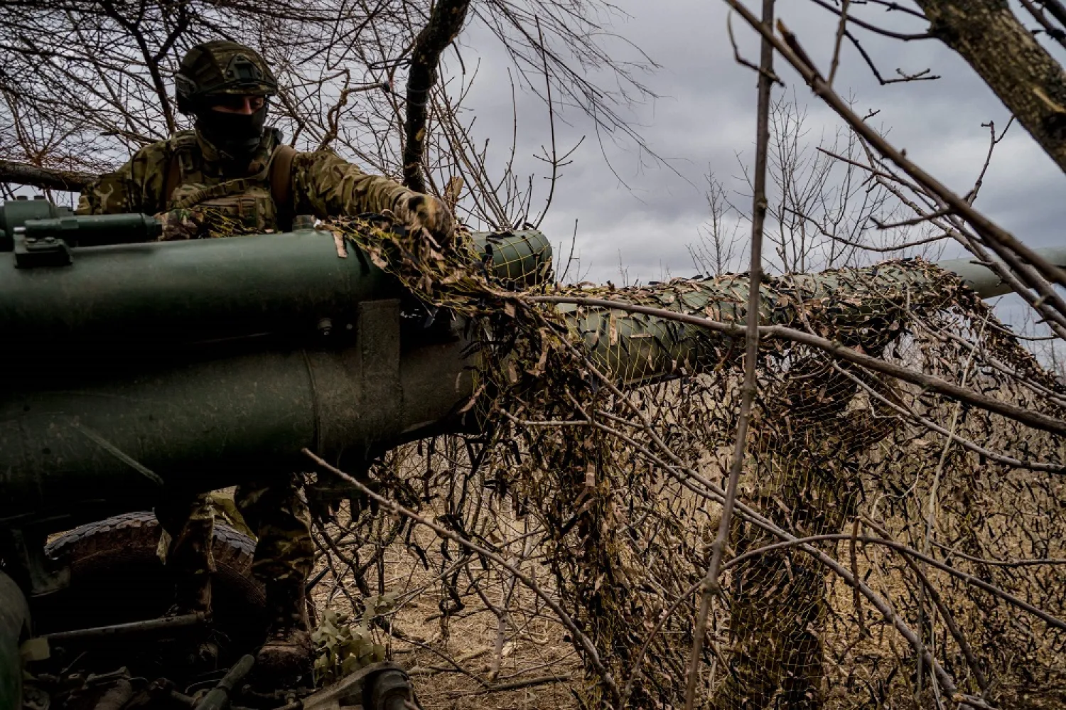 A Ukrainian serviceman sets up a camouflage net over a Msta-B howitzer, near the frontline town of Bakhmut on March 2, 2023, amid the Russian invasion of Ukraine. (AFP)