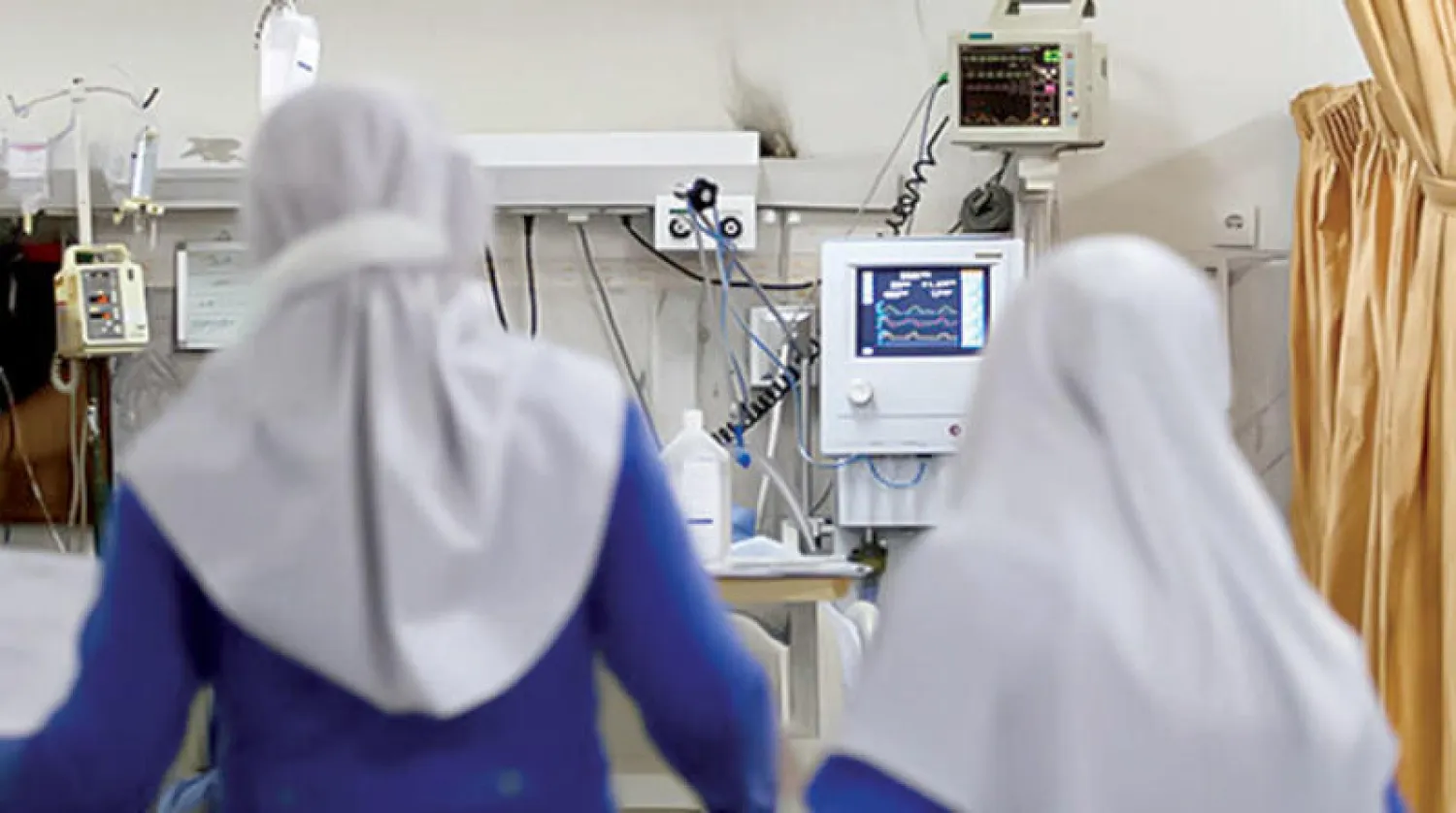 تلميذتان تتابعان الحالة الصحية لزميلتهما بغرفة عناية مركزة بمستشفى في قم (همشهري)