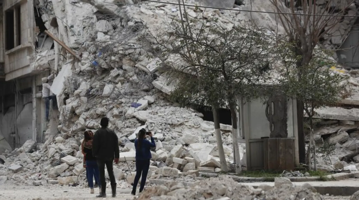 People stand by a building destroyed in recent earthquake in Aleppo, Syria, Monday, Feb. 27, 2023. (AP)
