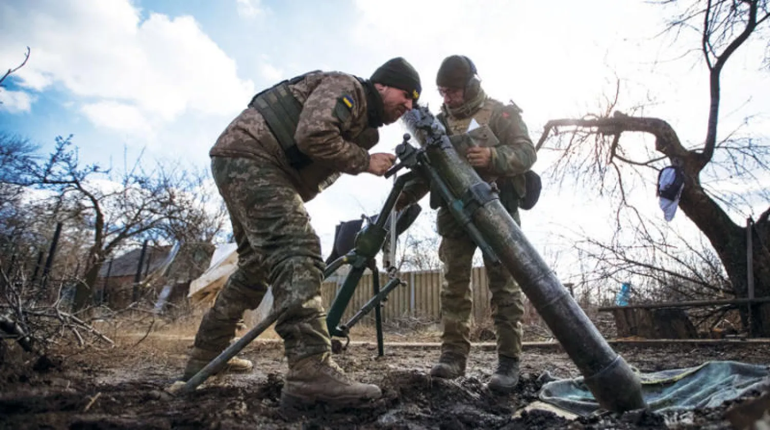 جنديان أوكرانيان يعدان لإطلاق قذيفة هاون قرب بلدة هورليفكا بإقليم دونيتسك (رويترز)