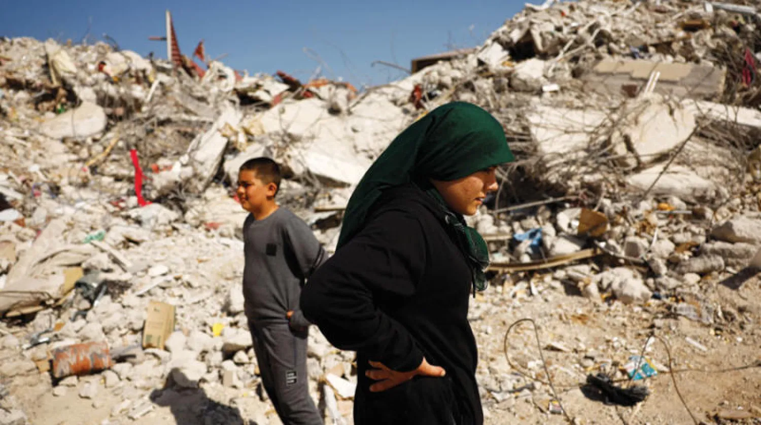 فاطمة جول أرسلان أمام المبنى الذي كانت تقيم فيه مع عائلتها وبقيت تحت أنقاضه خمسة أيام (رويترز)