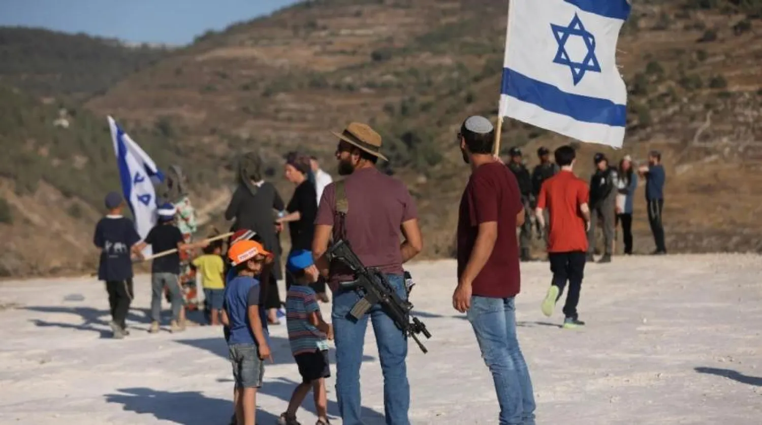 File photo: Israeli settlers gather near the settlement of Bat Ayin in the occupied West Bank on 21 June 2021. AFP
