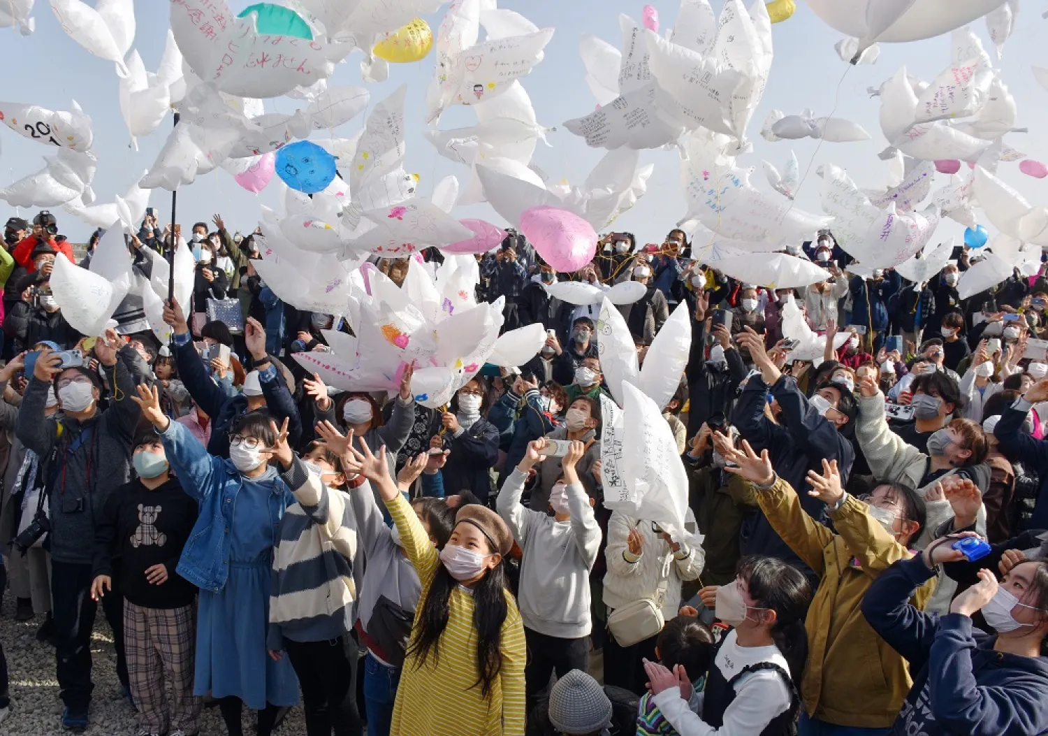 People release balloons into the air to offer prayers for the victims of the "Great East Japan Earthquake" on its 12th anniversary, in Natori, Miyagi Prefecture, northern Japan, 11 March 2023. (EPA)