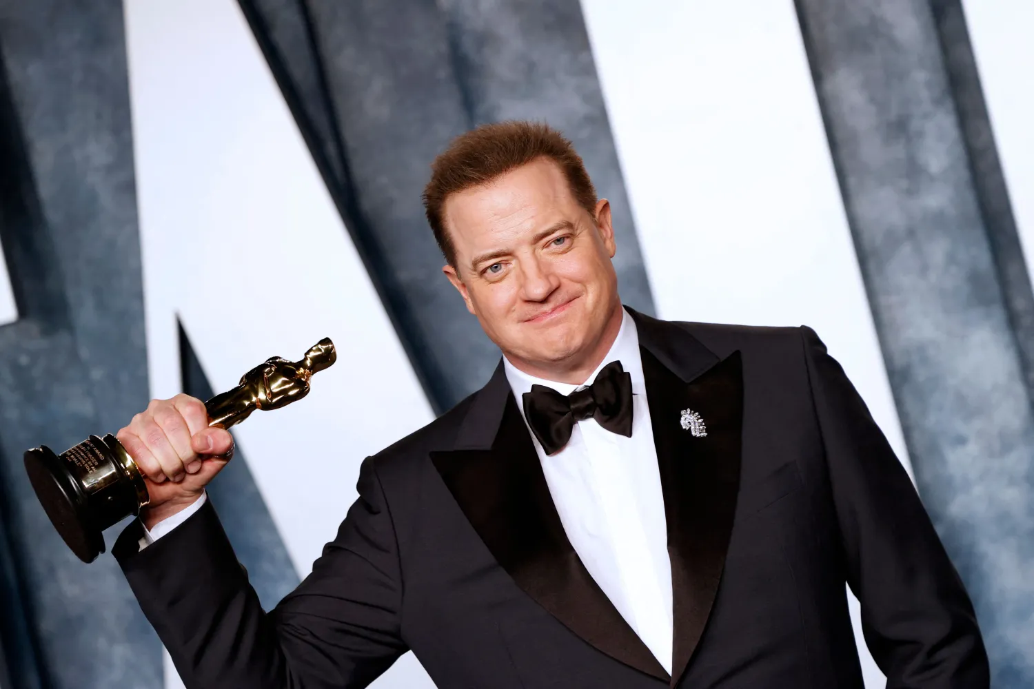 الممثل الأميركي بريندان فريزر يحمل جائزة الأوسكار عن أفضل ممثل في دور رئيسي عن فيلم «الحوت» (أ.ف.ب)
