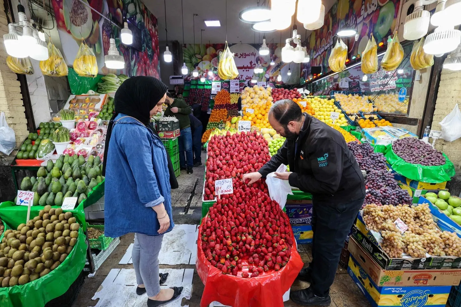 People shop at a market in Tehran on March 14, 2023. (AFP)