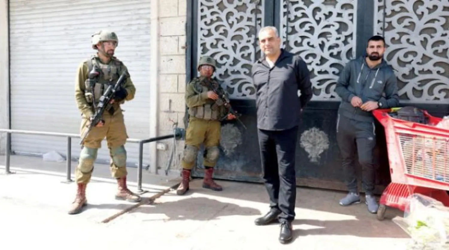 جنديان إسرائيليان أثناء منع فتح المتاجر الفلسطينية في حوارة (إ.ب.أ)