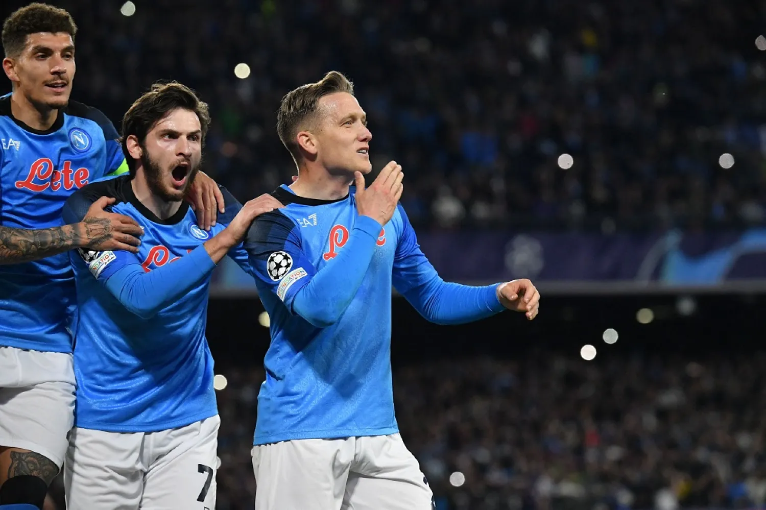 Napoli's Polish midfielder Piotr Zieliński (C) celebrates with Napoli's Italian defender Giovanni Di Lorenzo (L) and Napoli's Georgian forward Khvicha Kvaratskhelia after scoring a penalty and his side's third goal during the UEFA Champions League round of 16, second leg football match between SSC Napoli and Eintracht Frankfurt at the Diego-Maradona stadium in Naples on March 15, 2023. (AFP)
