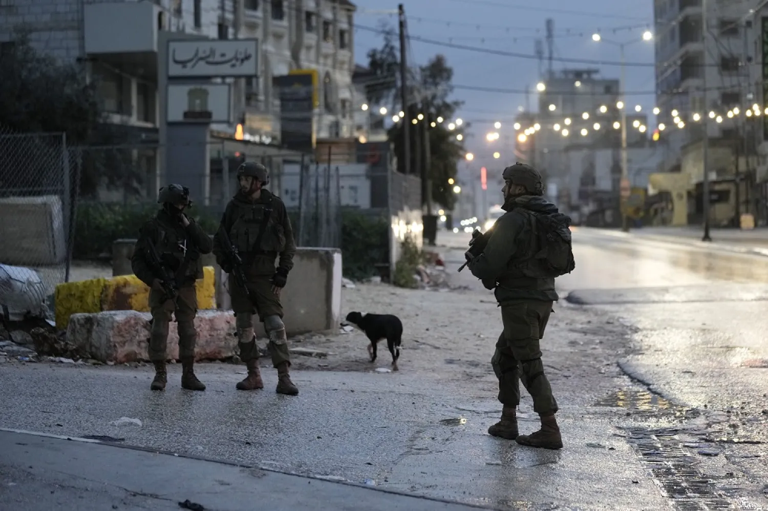  Israeli security forces work at the scene where officials say a Palestinian gunman opened fire at an Israeli vehicle, wounding two people, in the West Bank town of Hawara, Sunday, March 19, 2023. (AP) 