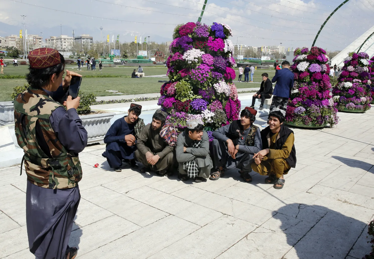 مجموعة من اللاجئين الأفغان يقفون لالتقاط صورة تذكارية ساحة آزادي (الحرية) في ساحة آزادي (الحرية) في طهران (إ.ب.أ)