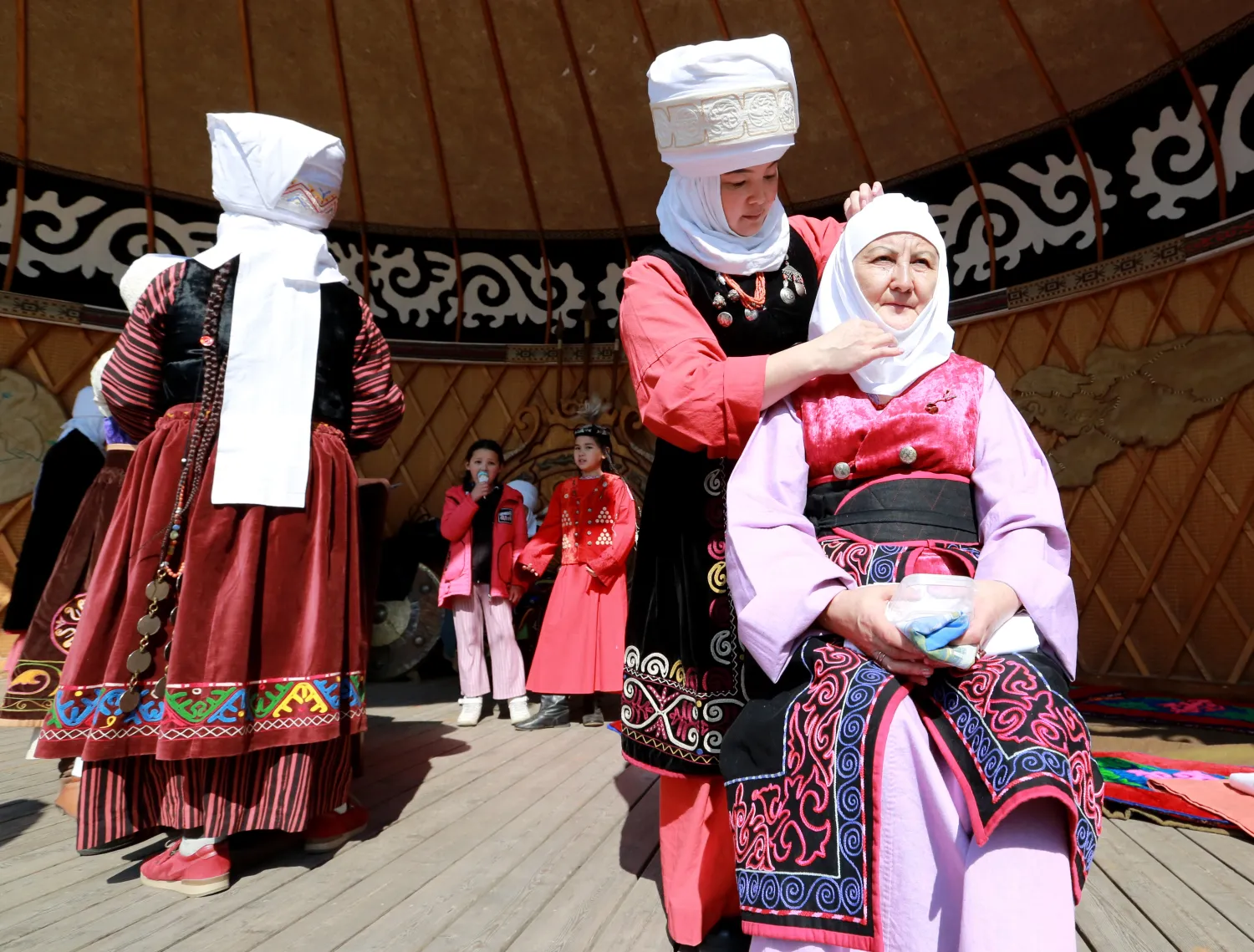 نساء يرتدين أزياء تقليدية في بيشكيك في قرغيزستان (إ.ب.أ)