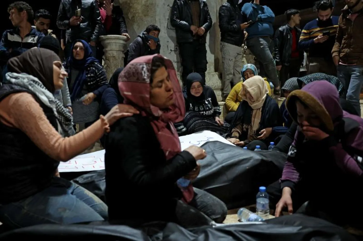 أقارب الضحايا قبيل تشييع جثامينهم في جنديرس (أ.ف.ب)