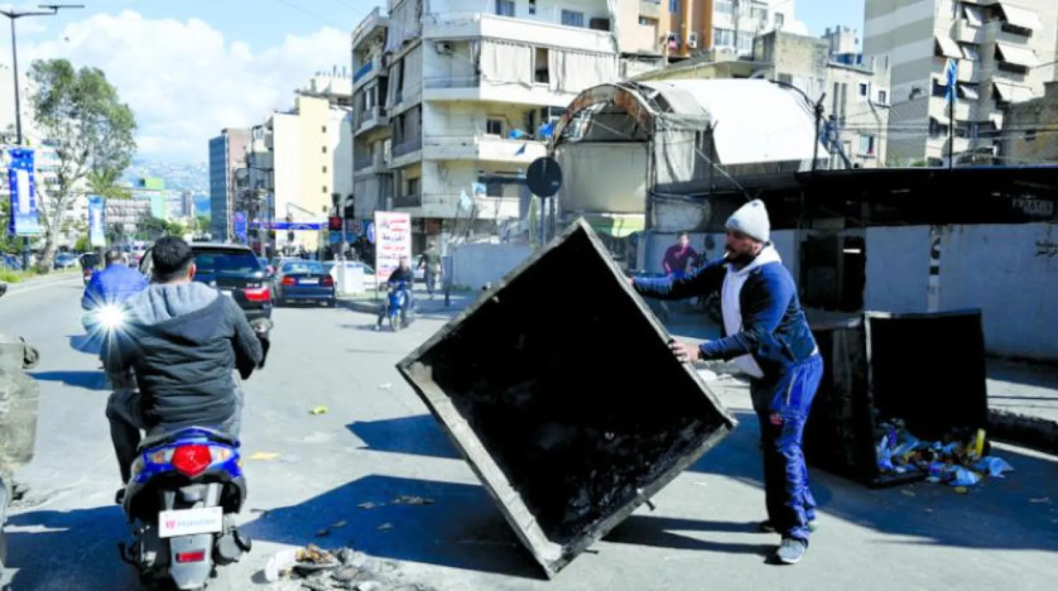 A protester blocks the main road with garbage bins as he takes part in a protest against the economic situation in the country, the high cost of living and the low purchasing power of the Lebanese pound, in Beirut, Lebanon, 21 March 2023. EPA/WAEL HAMZEH