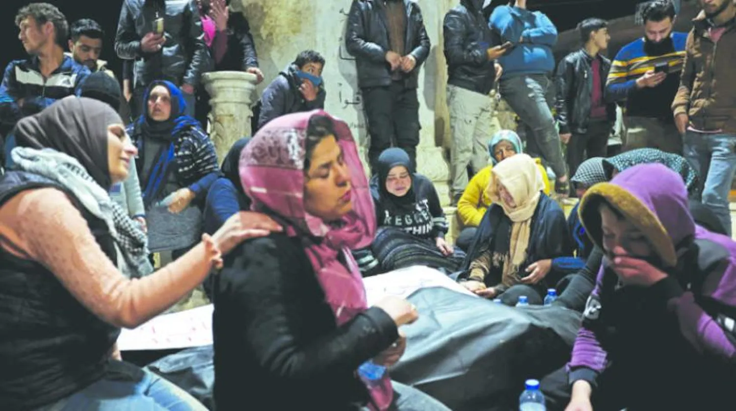 People mourn over the bodies of a Kurdish family killed by Turkish-backed fighters amid Nowruz celebrations in Jinderis in Aleppo on March 21, 2023. (Photo by OMAR HAJ KADOUR / AFP)