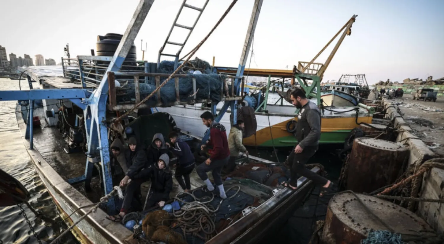 Palestinian fisherman Jihad al-Hissi and his sons aboard their boat at the seaport in Gaza City © MAHMUD HAMS / AFP
