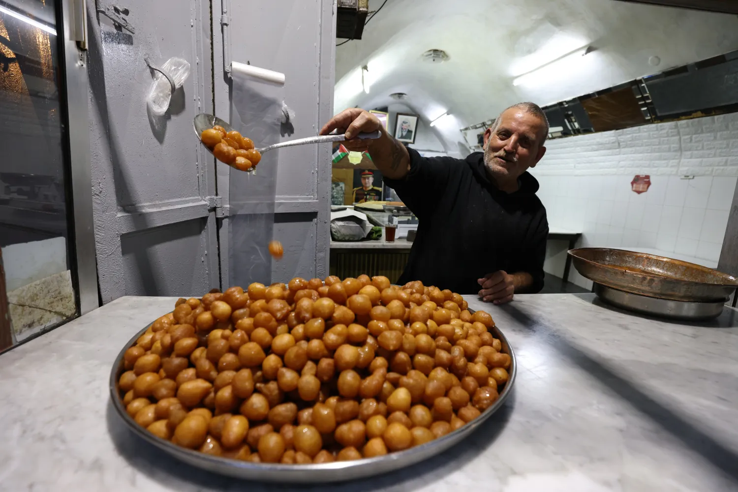 رجل فلسطيني يعد حلوى الزلابية في نابلس (إ.ب.أ)