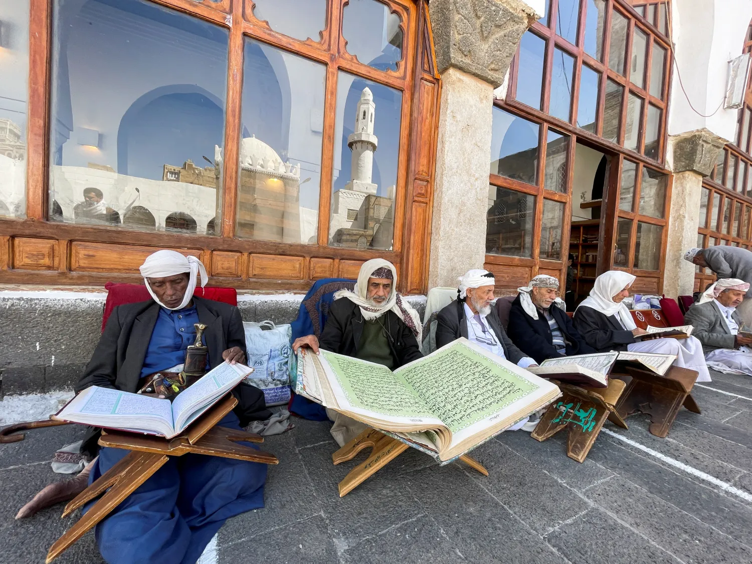 رجال يقرأون القرآن في الجامع الكبير أحد أقدم المساجد الإسلامية بصنعاء (رويترز)