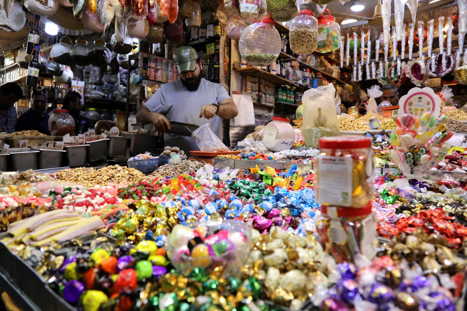 بائع للحلوى يحضر أحد الطلبات في العاصمة العراقية بغداد (إ.ب.أ)