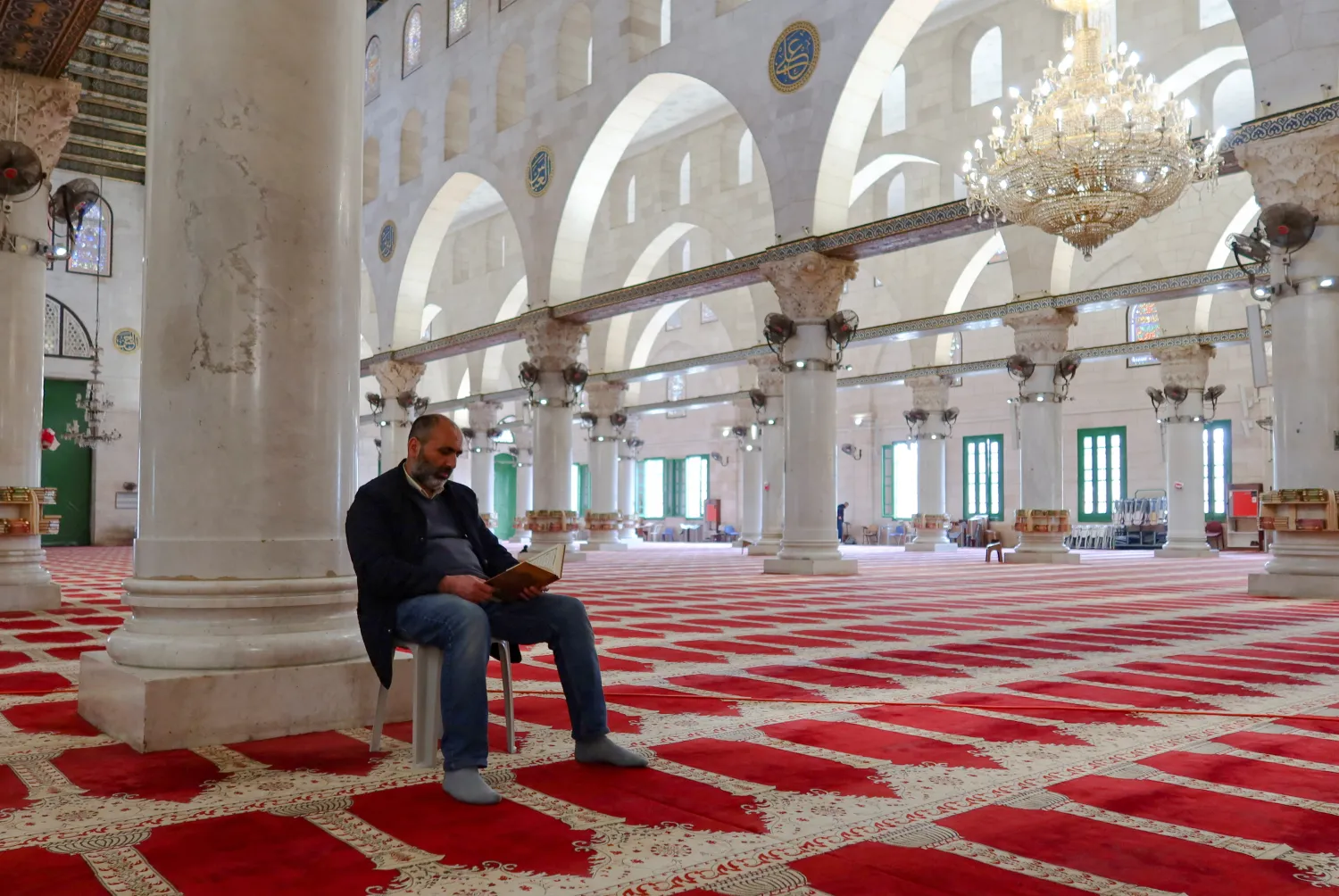 رجل فلسطيني يقرأ القرآن في المسجد الأقصى (رويترز)