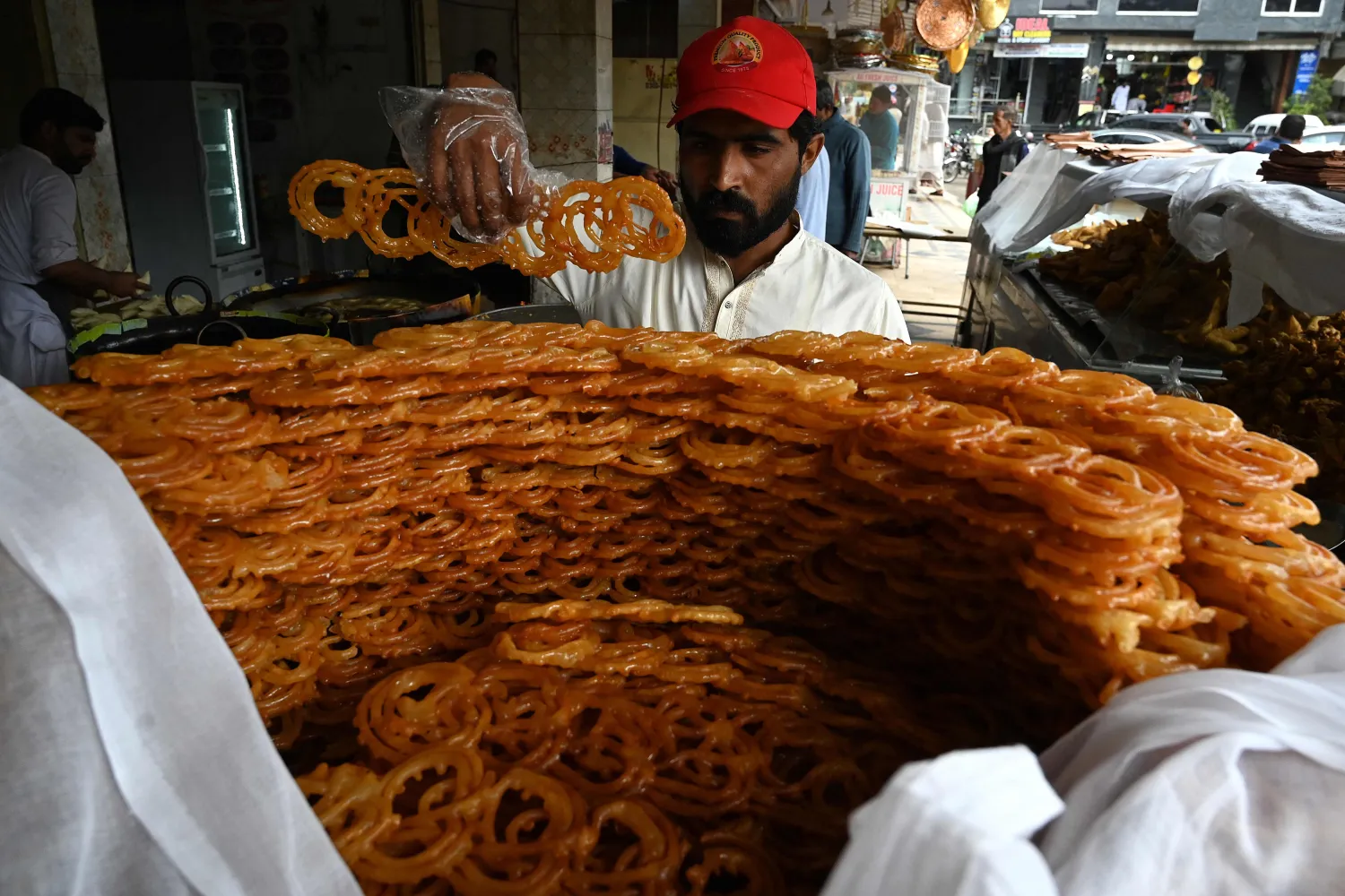 بائع ينظم الحلوى في إسلام آباد بباكستان (أ.ف.ب)