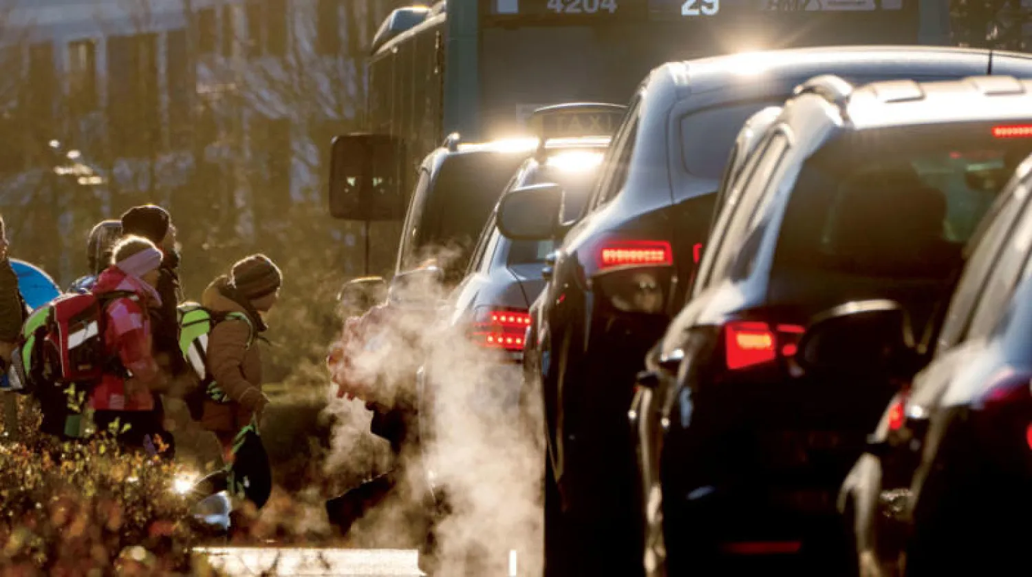 طابور من السيارات تخرج منه أبخرة العادم أثناء توجه الأطفال إلى المدرسة في فرانكفورت (أ.ب)