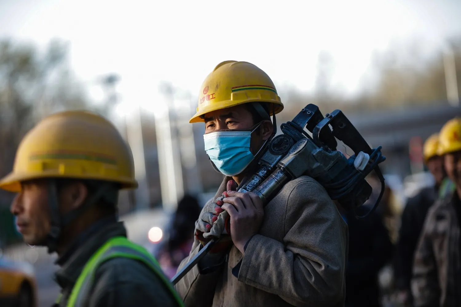 Workers walk on a street in Beijing, China, 27 March, 2023. (EPA)