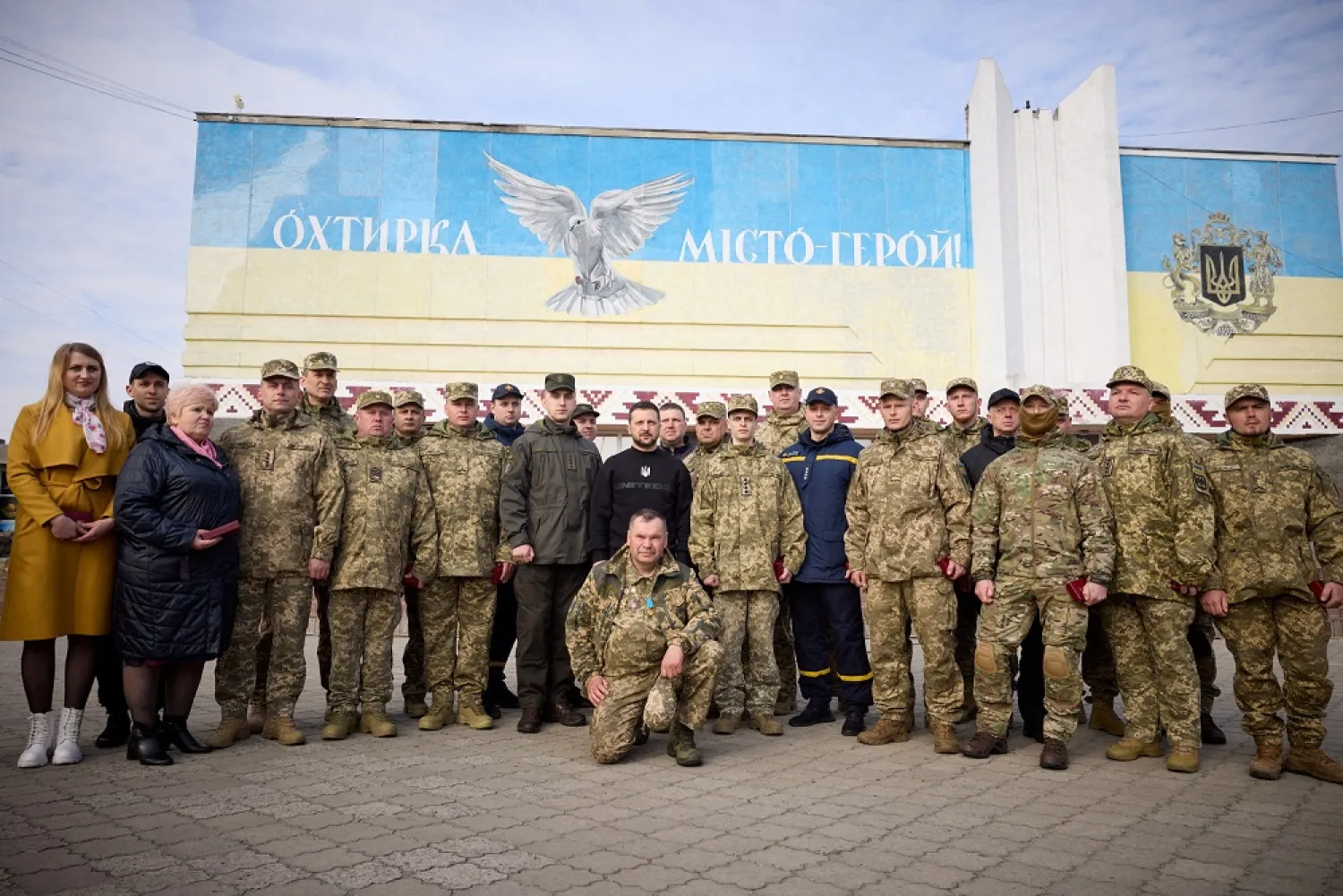 Ukraine's President Volodymyr Zelenskiy poses for a picture with Ukrainian service members and civilians, amid Russia's attack on Ukraine, during his visit in the town of Okhtyrka in Sumy region, Ukraine March 28, 2023. (Ukrainian Presidential Press Service/Handout via Reuters)