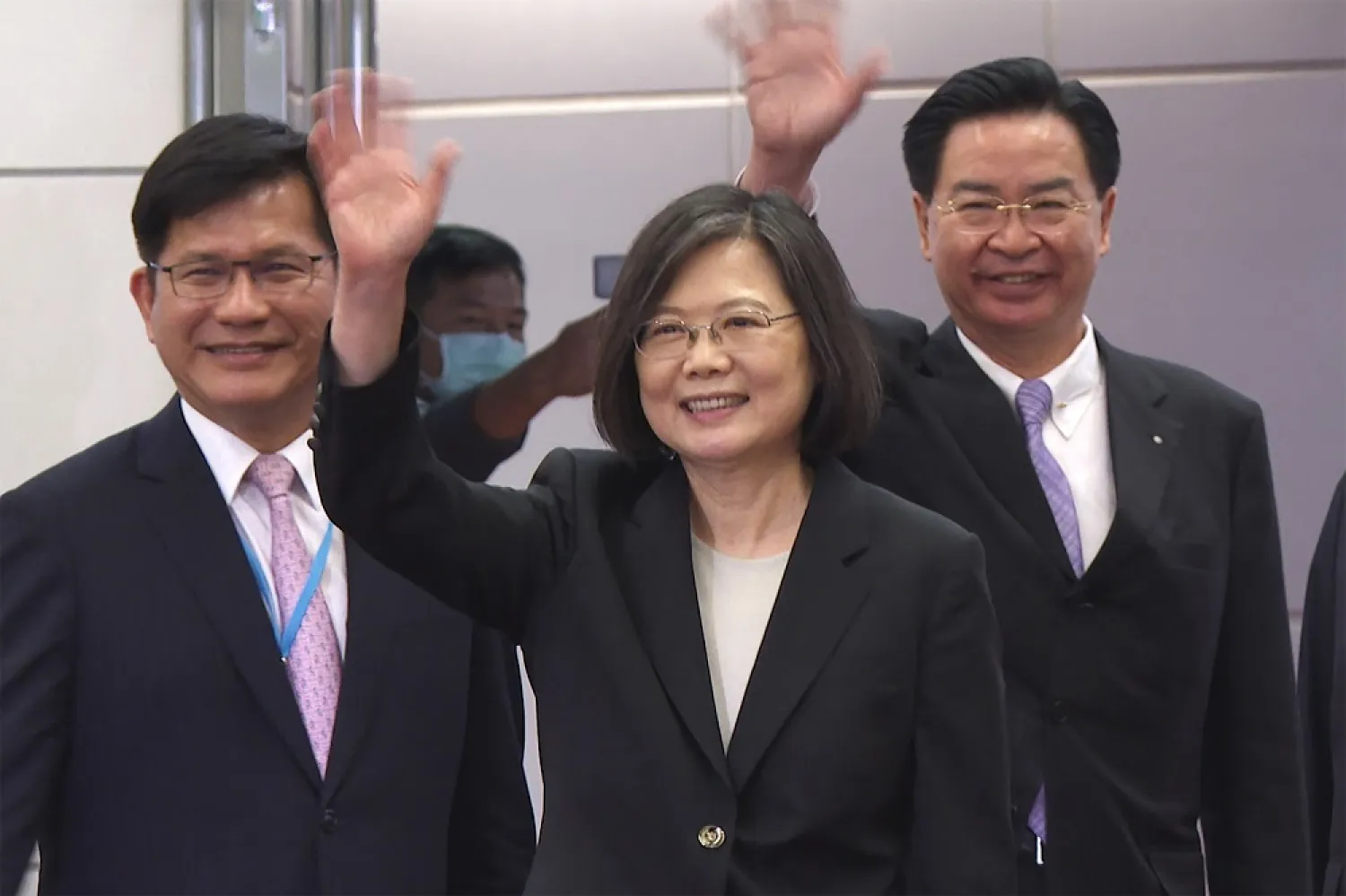 In this image made from video, Taiwan's Presidential office secretary general Lin Chia-lung, left, President Tsai Ing-wen, center, and Foreign Minister Joseph Wu wave before Tsai's departure on an overseas trip at Taoyuan International Airport in Taipei, Taiwan, Wednesday, March 29, 2023. (AP)