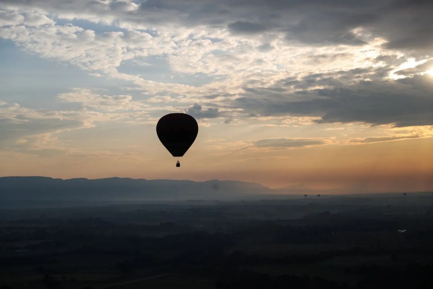 A hot-air balloon pilot pilots a hot-air balloon over Johannesburg, South Africa, May 15, 2022. REUTERS/Sumaya Hisham