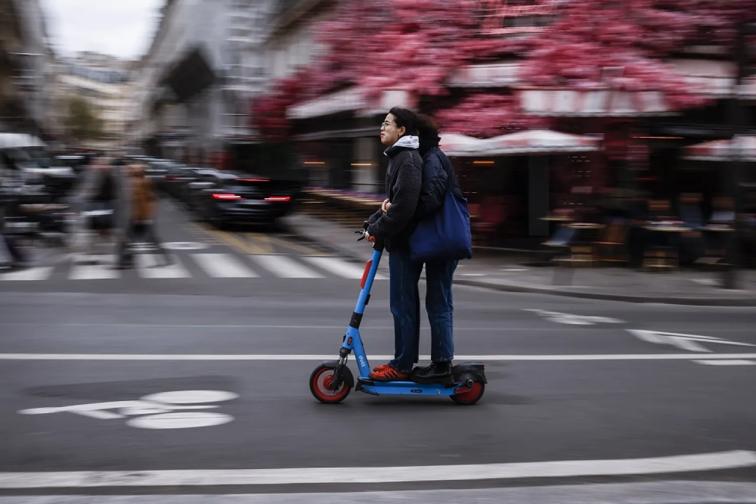 People ride a self-service e-scooter in Paris, France, 01 April 2023. (EPA)
