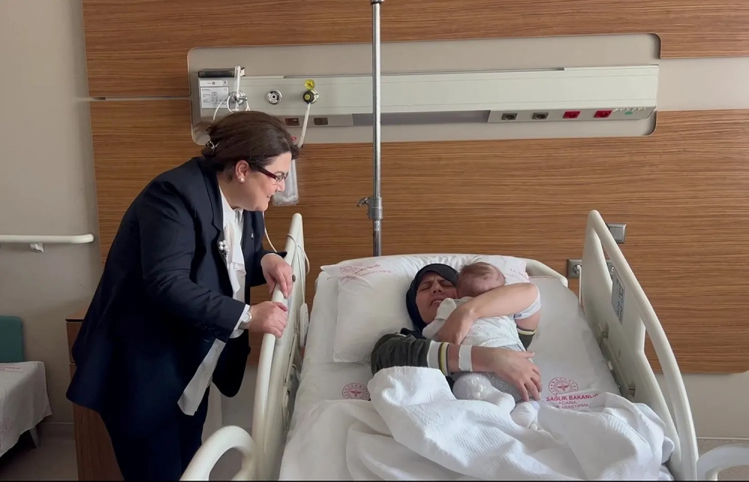 Earthquake survivor mother Yasemin Begdas reunites with her baby girl Vetin as Derya Yanik, Minister of Family and Social Services, looks on at a hospital in Adana, Türkiye March 31, 2023. (Ministry of Family and Social Services/Handout via Reuters)