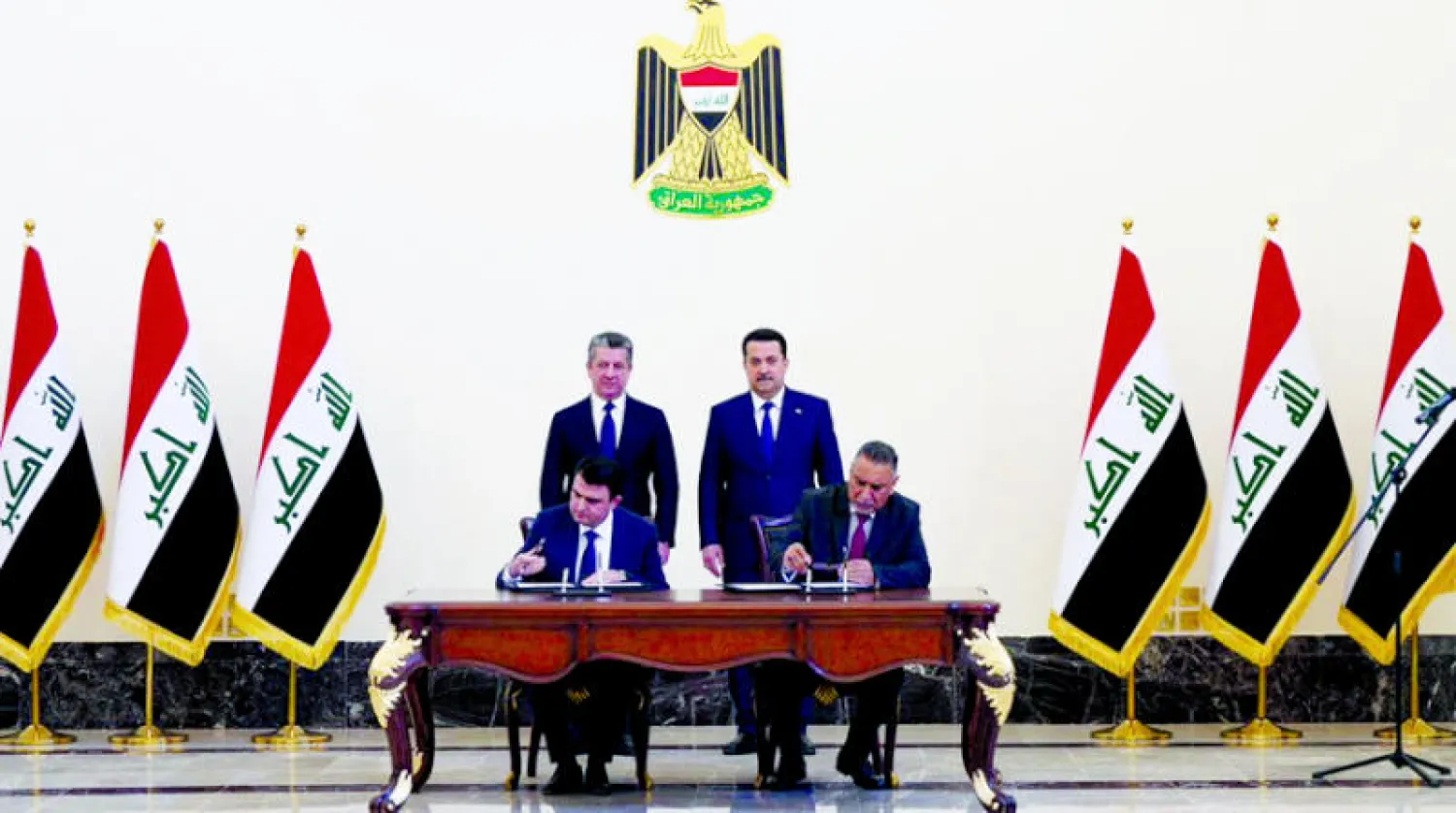 السوداني وبارزاني يرعيان توقيع الاتفاق في بغداد أمس (رويترز)