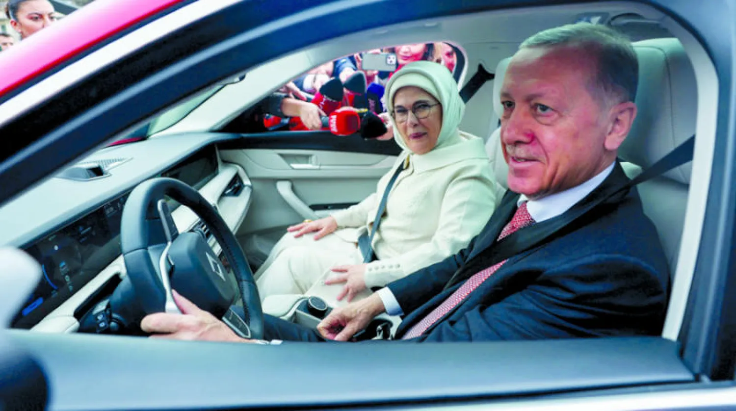 إردوغان وبجانبه زوجته أمينة يقود سيارة كهربائية صنع تركيا، في أنقرة أول من أمس (أ.ف.ب)