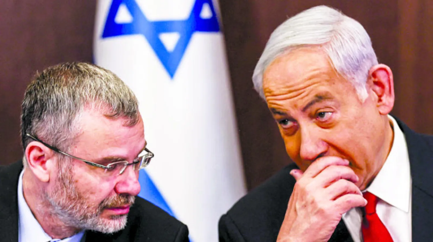 نتنياهو يتحدث مع وزير العدل ياريف ليفين خلال الاجتماع الأسبوعي في مكتب رئيس الوزراء الأحد (أ.ف.ب)