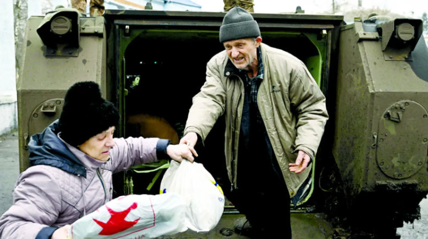 مدنيون تم إخلاؤهم من باخموت بواسطة مدرعات عسكرية أوكرانية (أ.ف.ب)