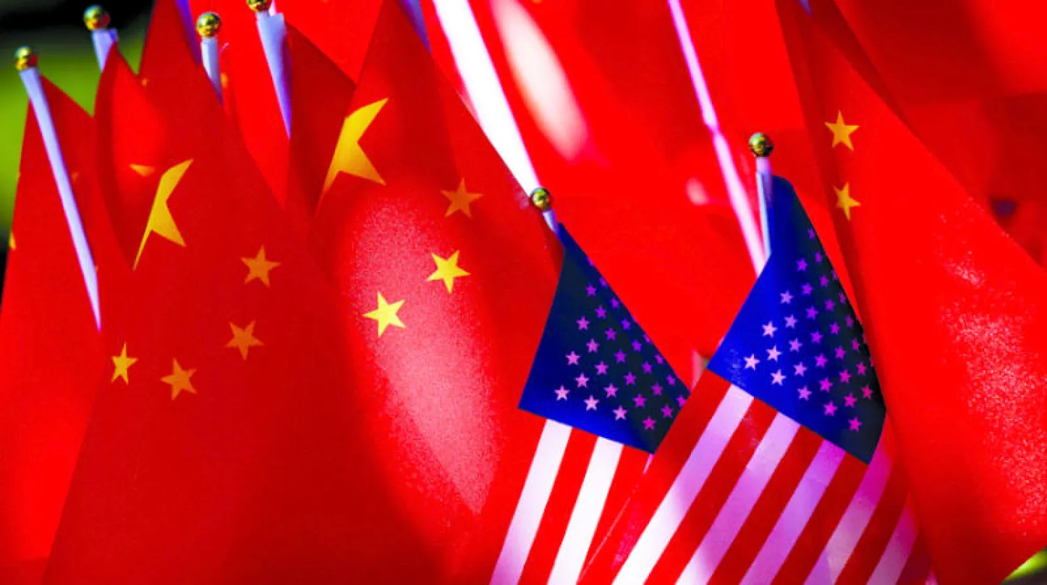 أعلام صينية وأميركية على دراجة ثلاثية العجلات في بكين في سبتمبر 2018 (أ.ف.ب)