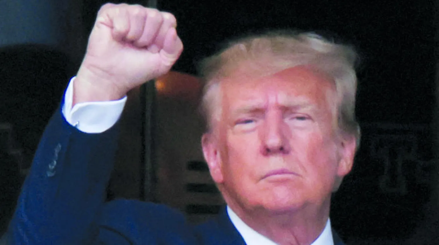 ترمب مغادراً «ترمب تاور» في نيويورك في طريقه إلى محكمة مانهاتن أمس (رويترز)