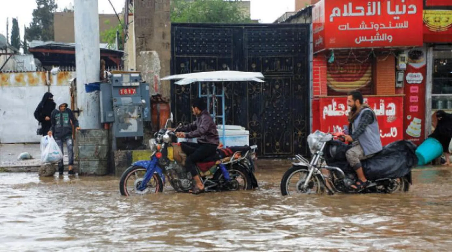 Yemenis ride motorcycles through a flooded street following heavy rain in Sanaa, Yemen (AFP)