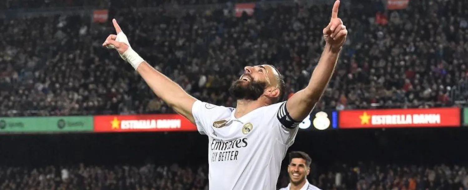 بنزيمة يحتفل بأحد أهدافه في شباك برشلونة (أ.ف.ب)