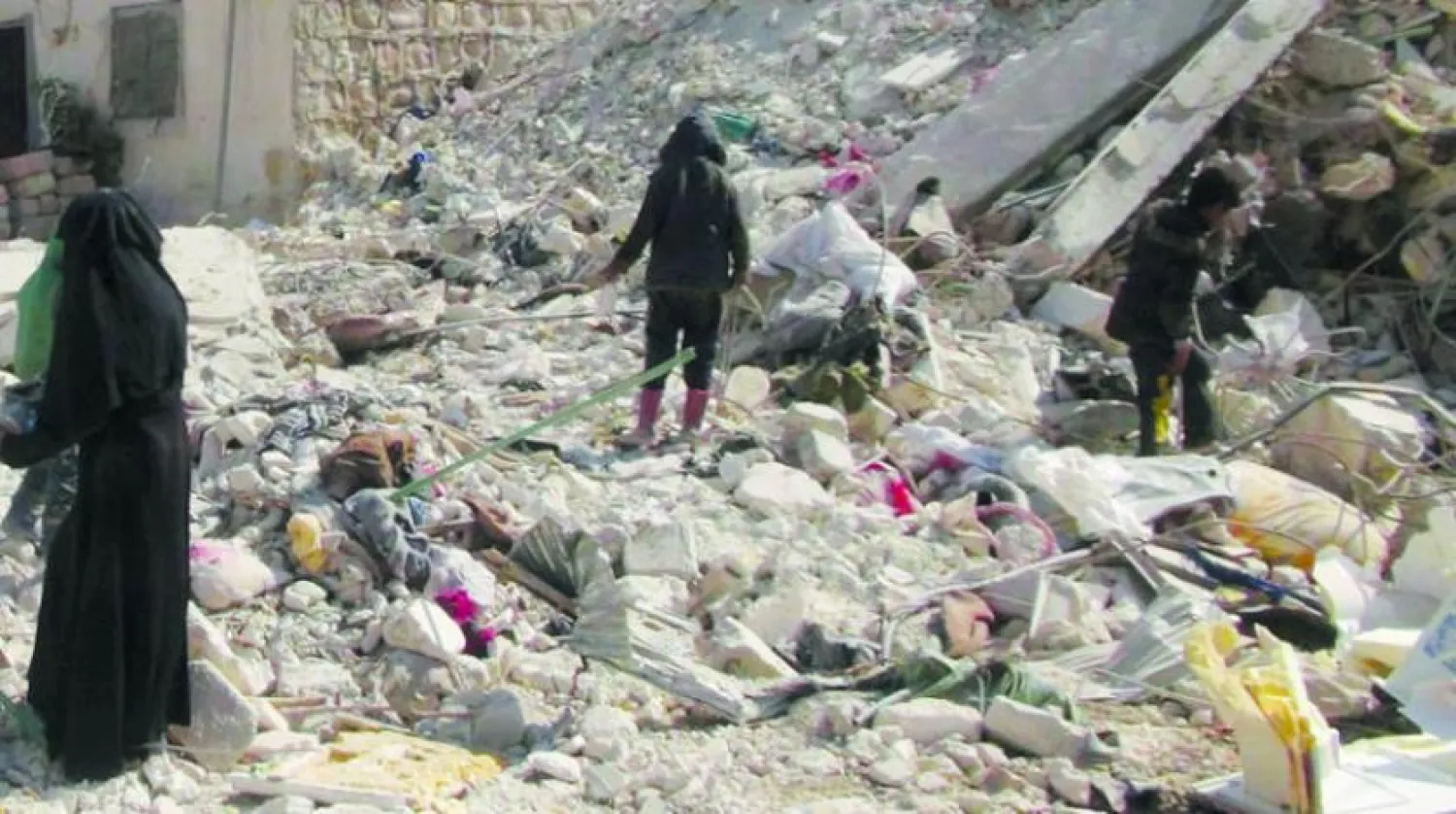 Bir kadın ve çocukları, Cinderes bölgesindeki enkazlar arasında hurda arıyor (Şarku’l Avsat)