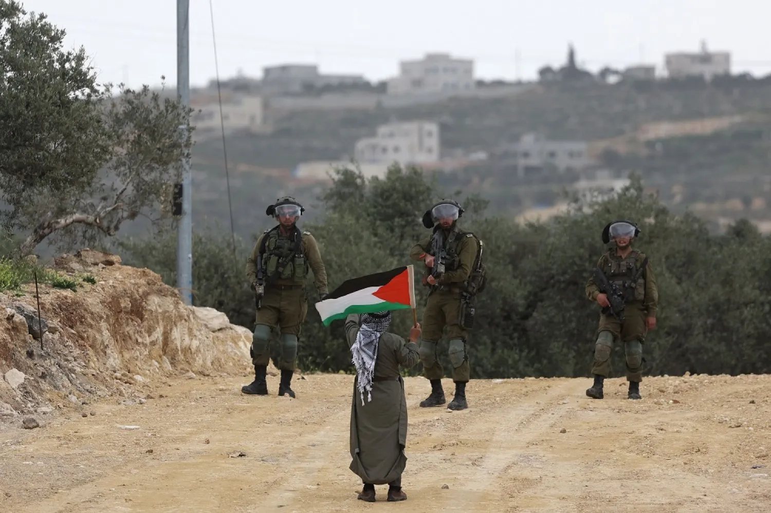 A Palestinian man confronts Israeli soldiers during a protest in the village of Beita, south of Nablus in the occupied West Bank, on April 10, 2023, against a march by settlers to the nearby Israeli outpost of Eviatar. (AFP) 