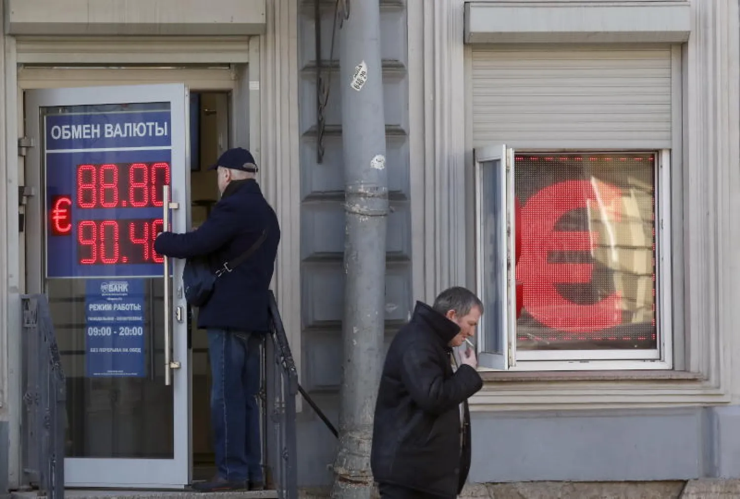 شاشة تعرض أسعار العملات أمام محل صرافة في روسيا (إ.ب.أ)