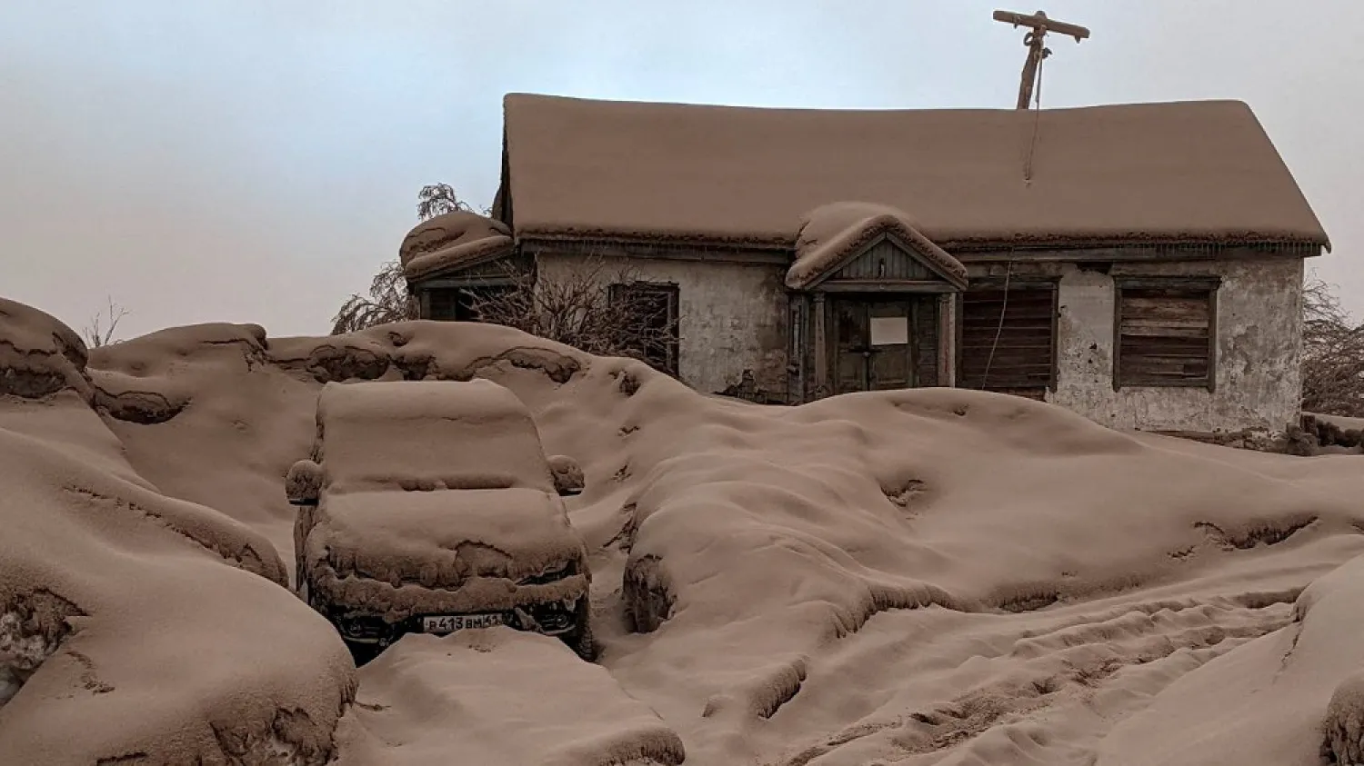 A view shows a house and a car covered in volcanic dust following the eruption of Shiveluch volcano in Kamchatka region, Russia April 11, 2023 in this picture obtained from a handout. (Institute of Volcanology and Seismology/Handout via Reuters)